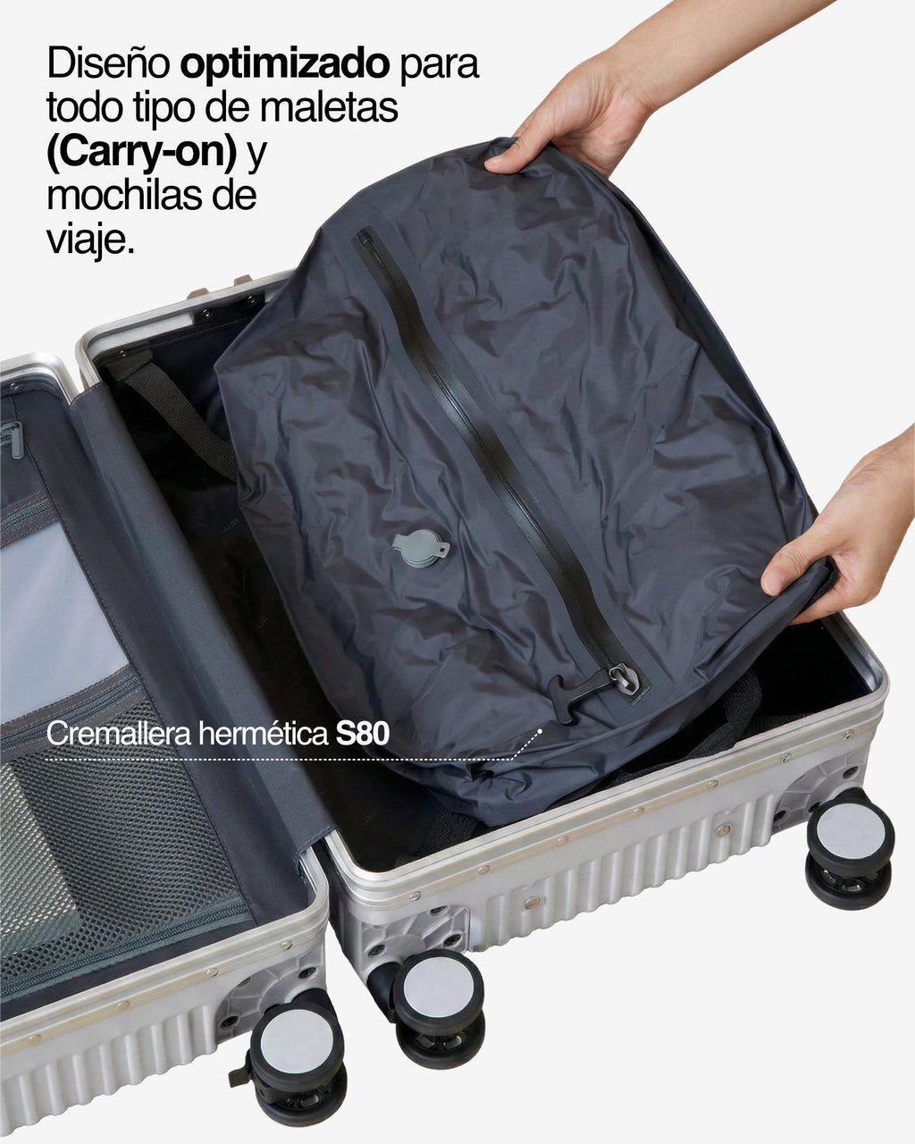 Manos colocando bolsa NVMA comprimida en maleta carry-on, destacando el ajuste optimizado y la cremallera hermética S80.