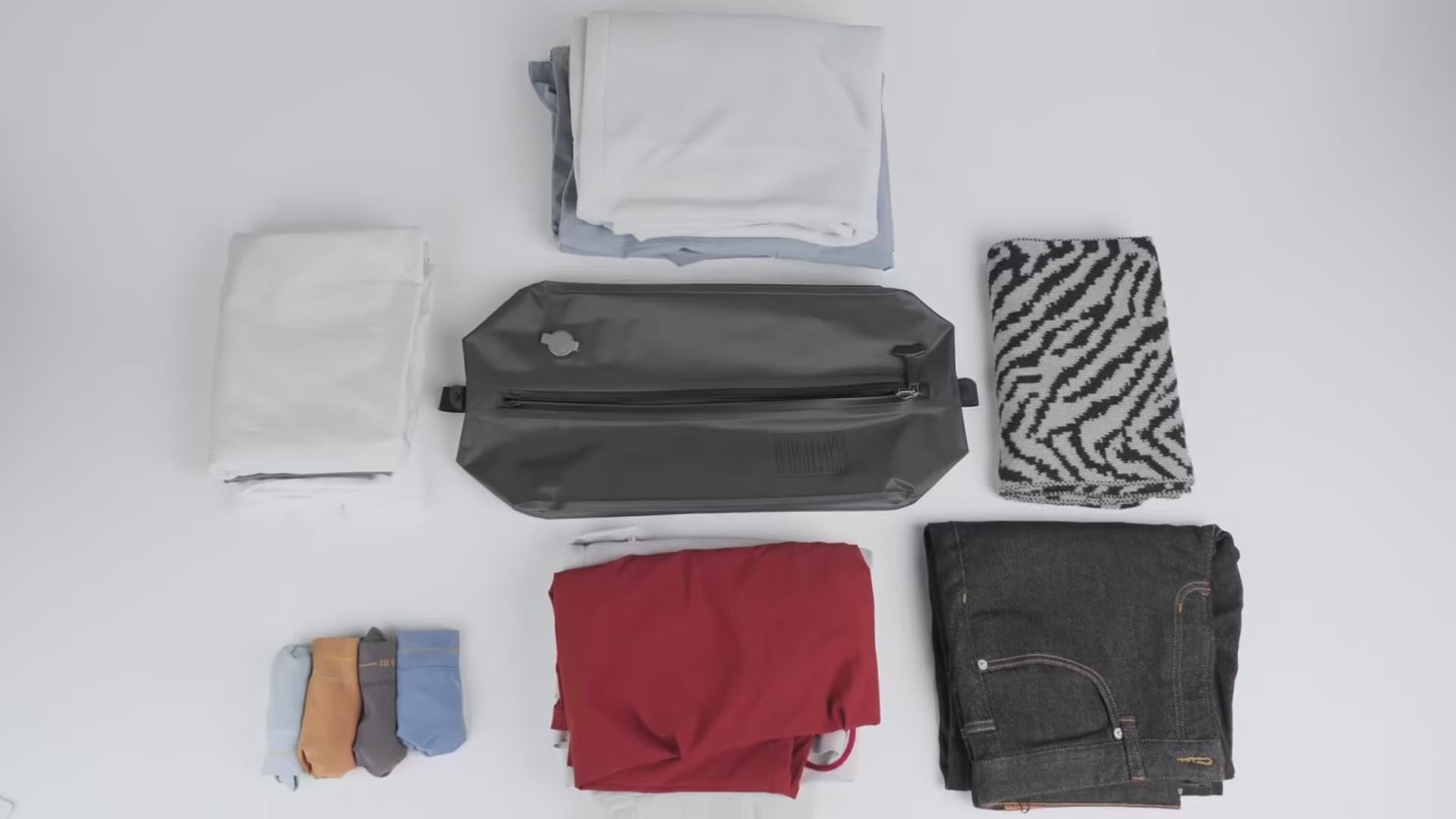 Demostración del Paso 1 (Sistema Gravity™): Usuario organizando prendas esenciales dentro del módulo de compresión para maximizar la capacidad volumétrica antes del sellado